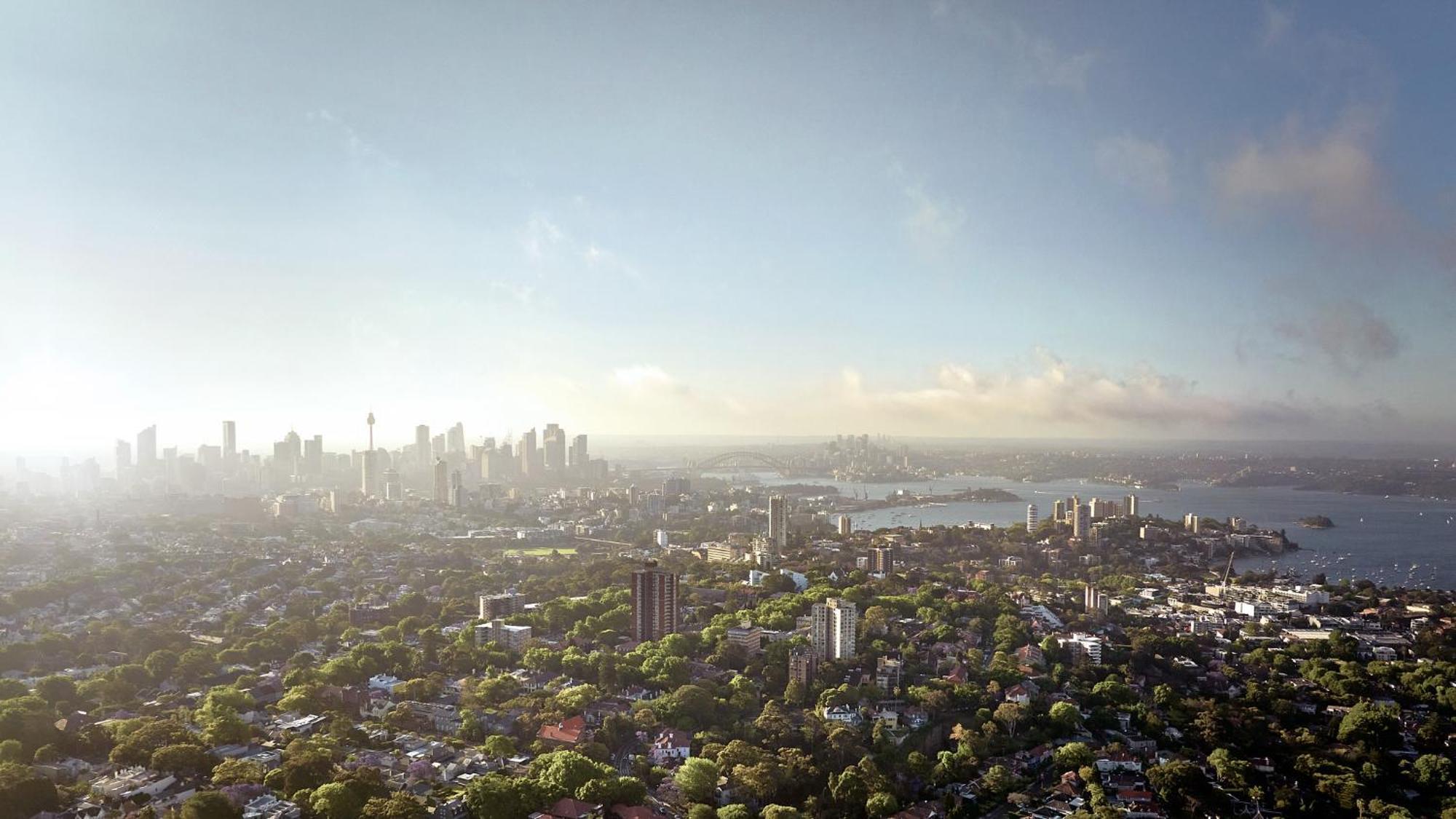 Meriton Suites Bondi Junction Sidney Dış mekan fotoğraf The photo shows a panoramic view of a city skyline, likely taken from a high vantage point. In the foreground, there are lush green trees and buildings, suggesting a suburban area. As the view extends towards the background, tall skyscrapers dominate